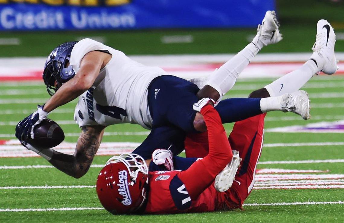 Fresno State cornerback Jaron Bryant tackles Nevada wideout Elijah Cooks, top, Saturday, Nov. 23, 2019 in Fresno. The Bulldogs lost 35-28, falling out of contention for a bowl game.