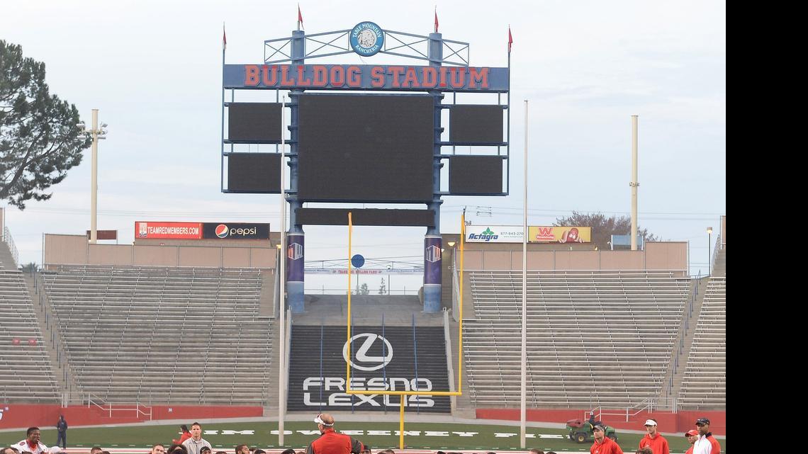 
Coach Tim DeRuyter addresses Fresno State football players during a December 2013 practice at Bulldog Stadium. Fresno State is upgrading the north end zone scoreboard (pictured) with a new high definition video board that will be more than twice the size of the existing scoreboard at 24 feet high and 66 feet wide, and will be accompanied by a 104-foot ribbon board.
