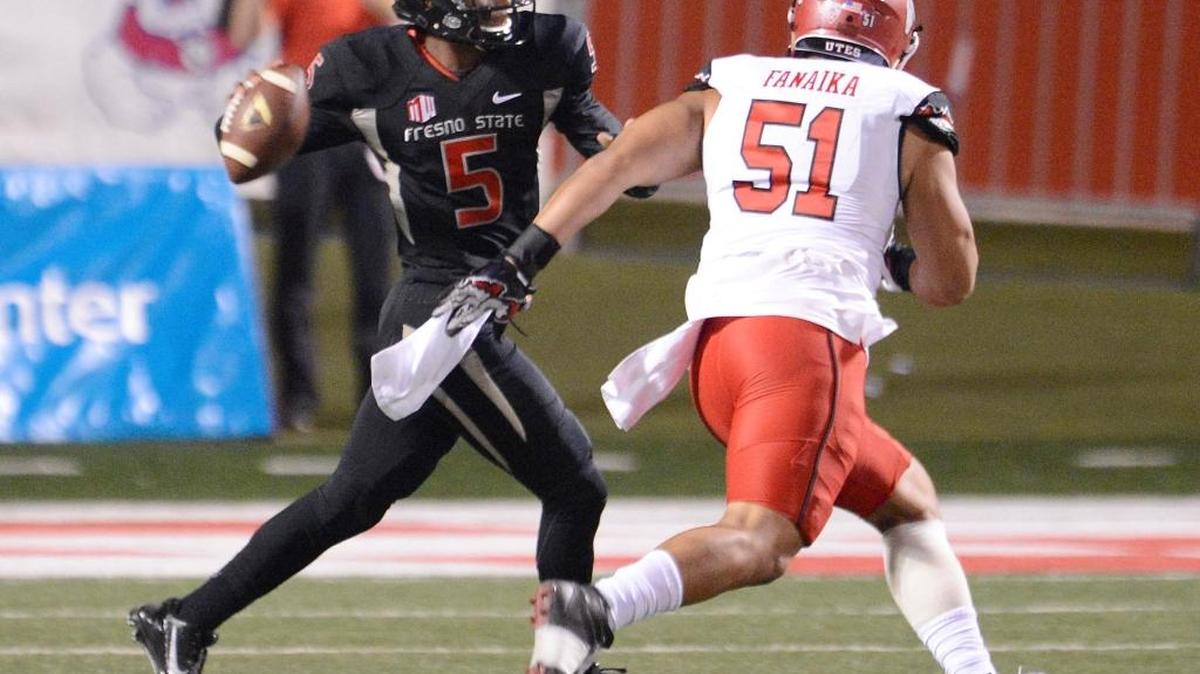 Fresno State quarterback Chason Virgil looks for an open receiver while being chased by Utah’s Jason Fanaika in their game at Bulldog Stadium, Saturday, Sept. 19, 2015.