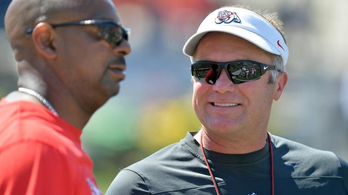 Fresno State coach Tim DeRuyter, right, defensive coordinator Lorenzo Ward and the rest of the Bulldogs’ coaching staff will be able to work off-campus satellite camps after the NCAA’s reversal of a three-week-old ban. The Bulldogs are among the programs that see the camps as a key evaluation tool as well as an avenue to greater exposure for high school athletes unable to travel far from home.