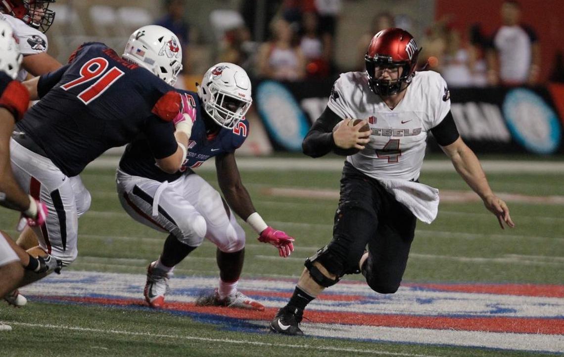 UNLV quarterback Johnny Stanton tries to avoid Fresno State defensive tackle Nathan Madsen (91) and defensive end Tobenna Okeke (56) during the second half of the Bulldogs’ 26-16 loss in Fresno, Saturday, Oct. 28, 2017. Stanton, starting in place of injured Armani Rogers, hit 17 of 29 passes for 155 yards and rushed for another 38 yards and one touchdown for the Rebels.