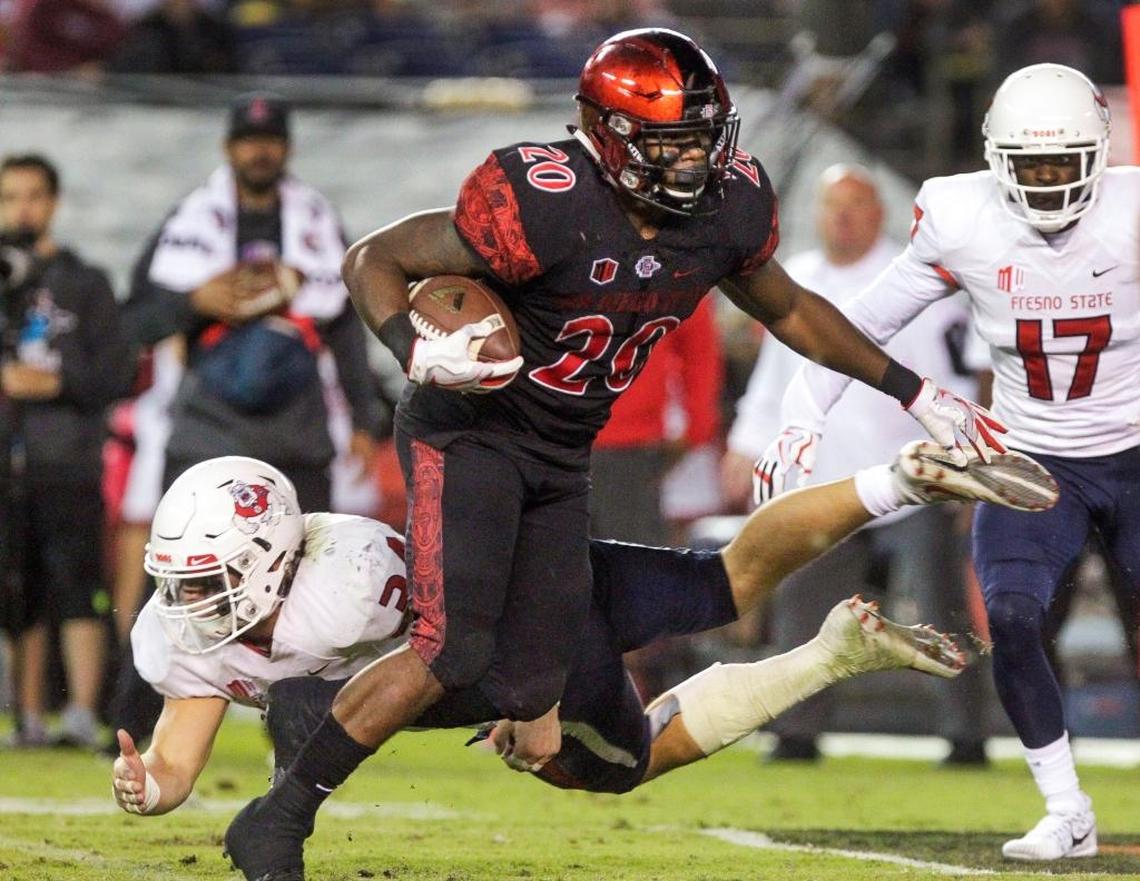 San Diego State running back Rashaad Penny carries the ball as Fresno State's George Helmuth just misses dragging him down by the ankles during the second quarter at SDCCU Stadium in San Diego on Saturday, Oct. 21, 2017. Penny went into the game ranked second in the Mountain West in rushing yards per game with 149.4, but the Bulldogs held him to just 69 yards on 15 plays.