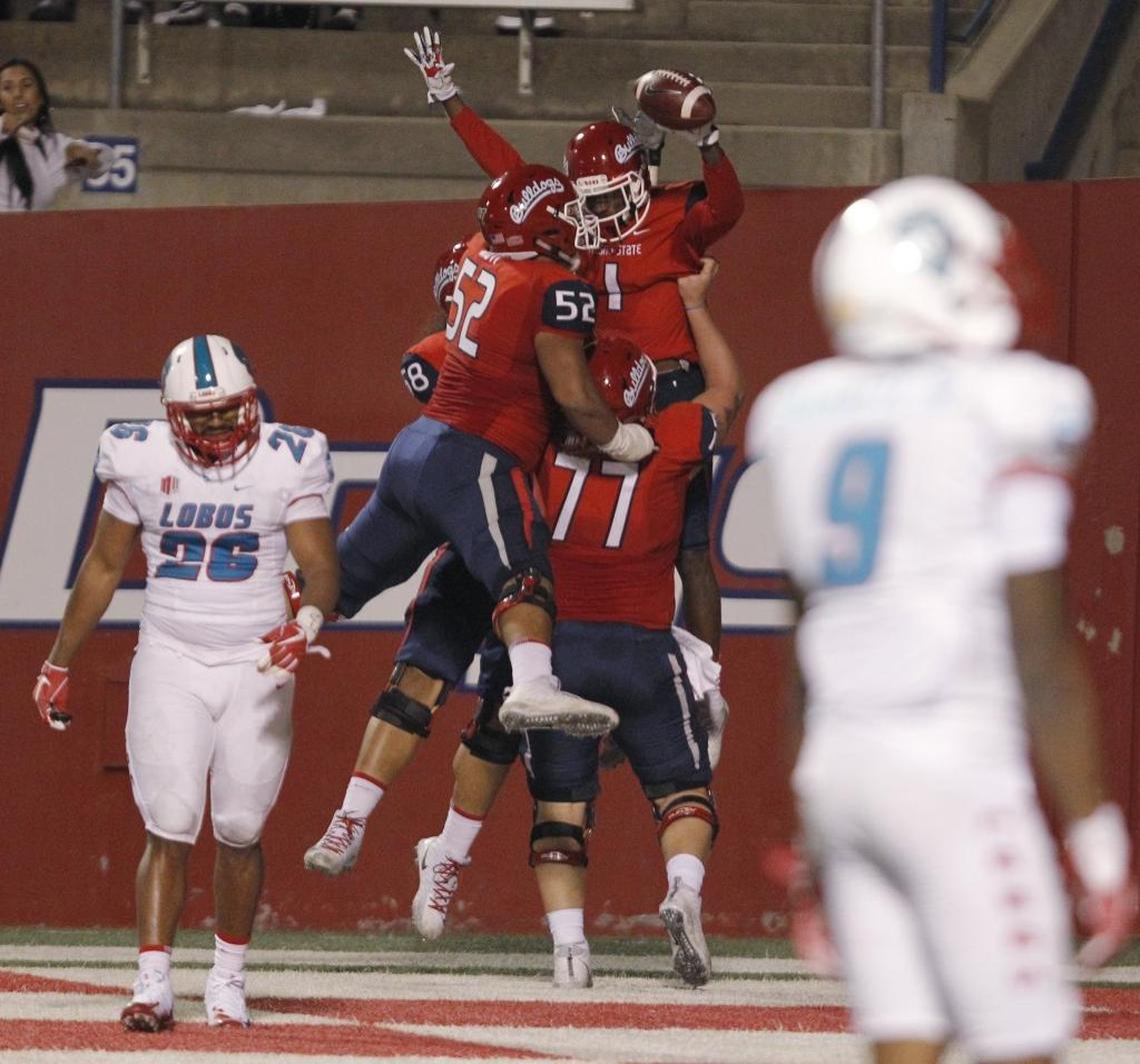 Fresno State center Aaron Mitchell (77) gives a boost to 310-pound guard Netane Muti (52) and wideout Jamire Jordan after Jordan caught a touchdown pass in the Bulldogs’ 38-0 victory over New Mexico at Bulldog Stadium, Saturday, Oct. 14, 2017.