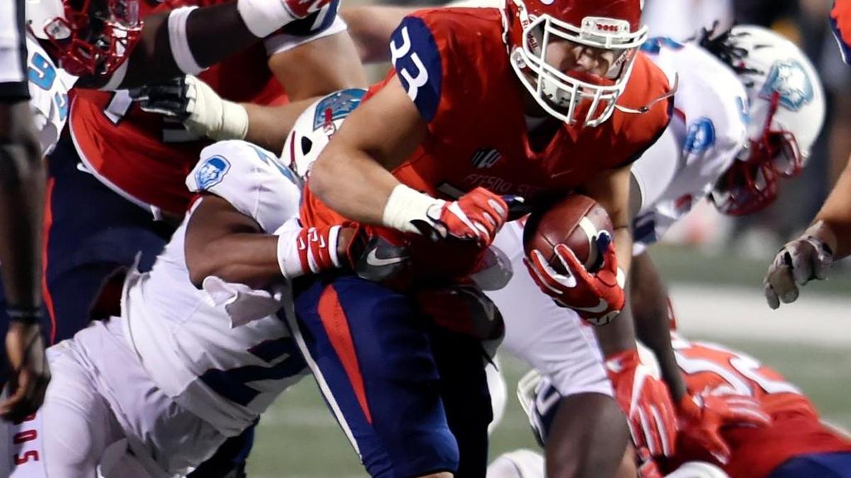 Fresno State’s Josh Hokit drives up the middle being dragged down by New Mexico’s Kimmie Carson in second-half action Oct. 14, 2017 in Fresno. The Bulldogs shut out the Lobos 38-0.