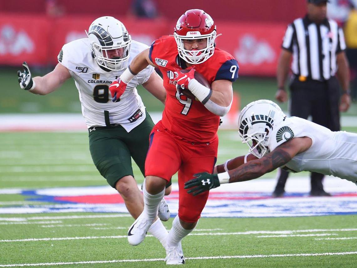 Fresno State’s Josh Hokit, center, runs through an attempted tackle by Colorado State’s Jan-Phillip Bombek, left, and Jamal Hicks, right, Saturday, Oct. 26, 2019 in Fresno.