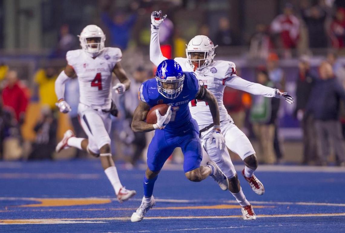 Boise State wide receiver Cedrick Wilson keeps on his feet after a long pass reception defended by Fresno State’s Jaron Bryant in the fourth quarter.