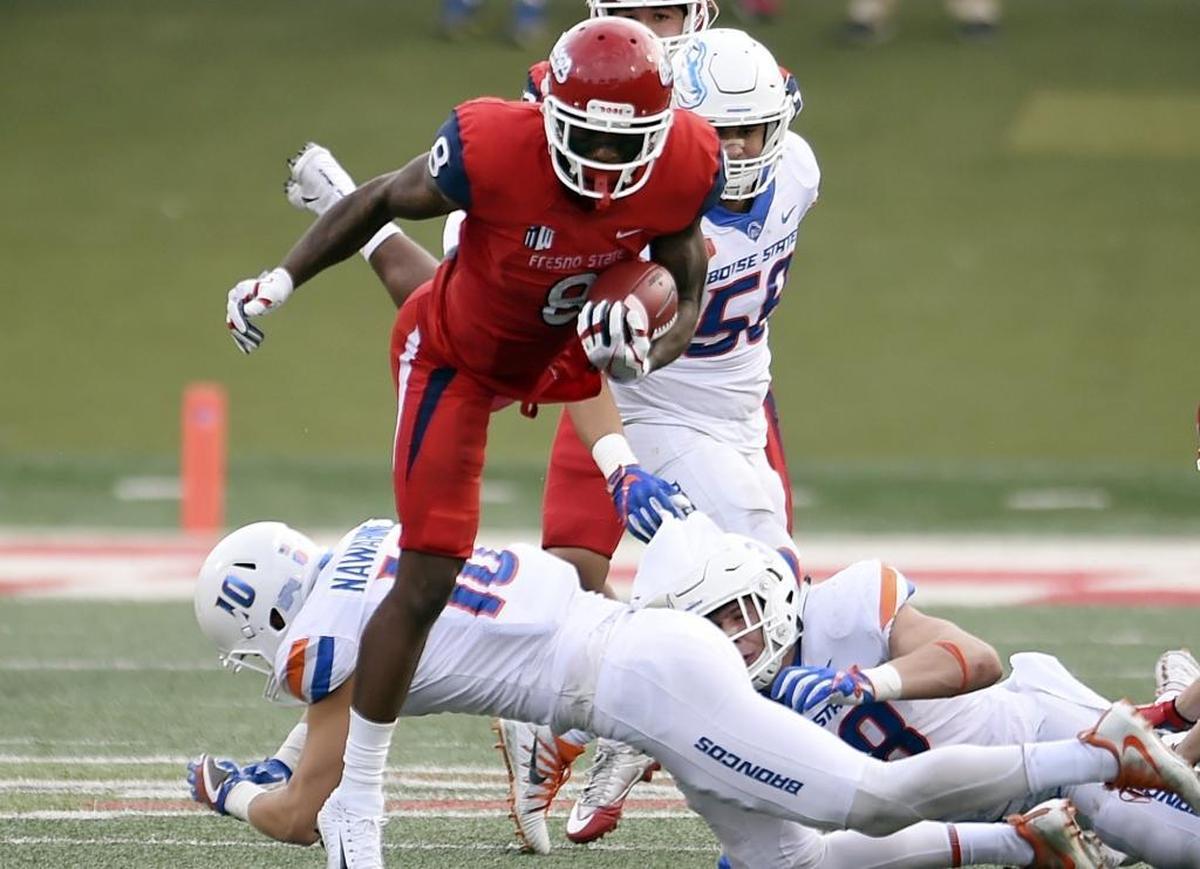 Fresno State’s Da’Mari Scott leaps over Boise State’s Kekoa Nawahine during second-half action in last week’s game. Scott is one of five redshirt seniors who received rings the last time Fresno State won the Mountain West Conference football championship, in 2013. The Bulldogs are playing at Boise State on Saturday, Dec. 2, for this year’s title.