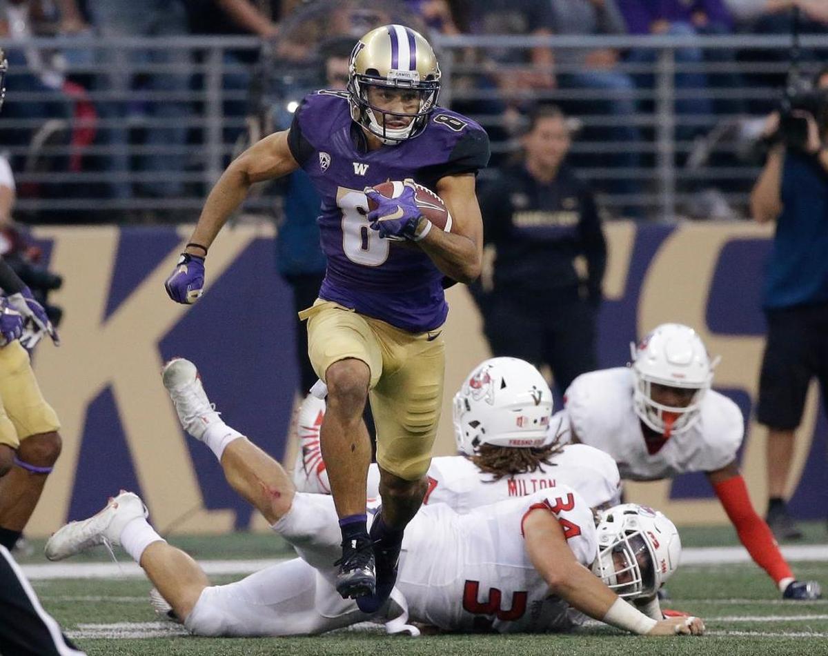 Washington's Dante Pettis (8) leaves several Fresno State defenders in his wake on his punt return for a touchdown in the first half of an NCAA college football game Saturday, Sept. 16, 2017, in Seattle. Pettis tied the NCAA career record for punt return touchdowns on the 77-yard return, the eighth of his career. It also was the third consecutive game Pettis has returned a punt for a touchdown, following victories over Rutgers and Montana.