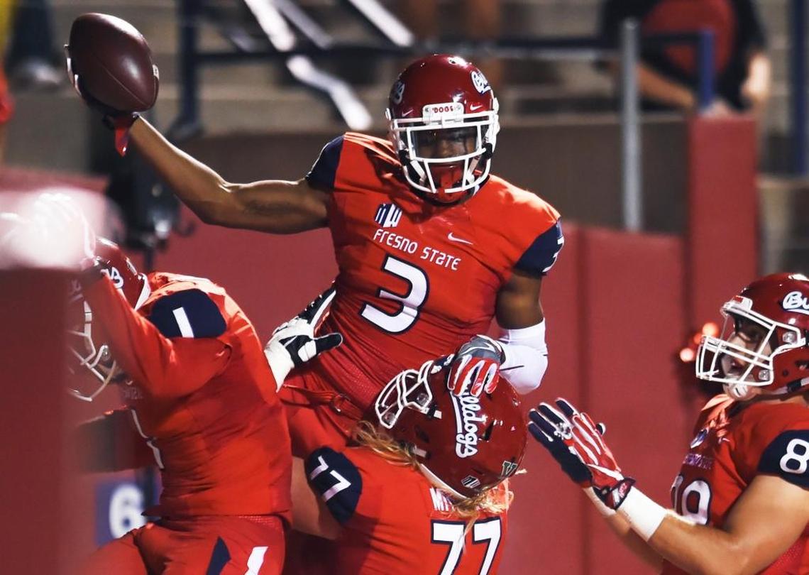 Fresno State wideout KeeSean Johnson, top, celebrates a touchdown against Nevada Saturday in Fresno. Johnson caught seven passes for 104 yards and three touchdowns in the Bulldogs’ 41-21 victory in their Mountain West Conference opener. It was the second time Johnson has had three touchdown receptions in a game. He also had three last season in a loss to Air Force.