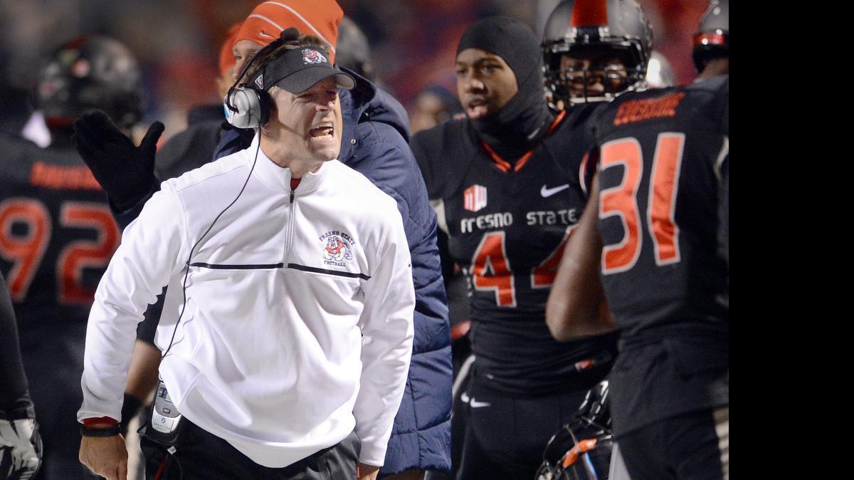 
Fresno State defensive coordinator Nick Toth encourages players during the Mountain West championship against Utah State at Bulldog Stadium on Dec. 7, 2013.
