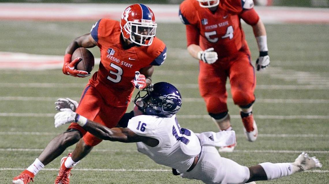 Fresno State wide out KeeSean Johnson, left, takes the ball upfield while trying to shake a tackle by Abilene Christian's Cedric Dale in their game at Bulldog Stadium Thursday, Sept. 3, 2015. With Johnson, KeeSean Johnson and the return of Da’Mari Scott from a redshirt season the Bulldogs have one of the deepest receivers groups in the Mountain West this season.