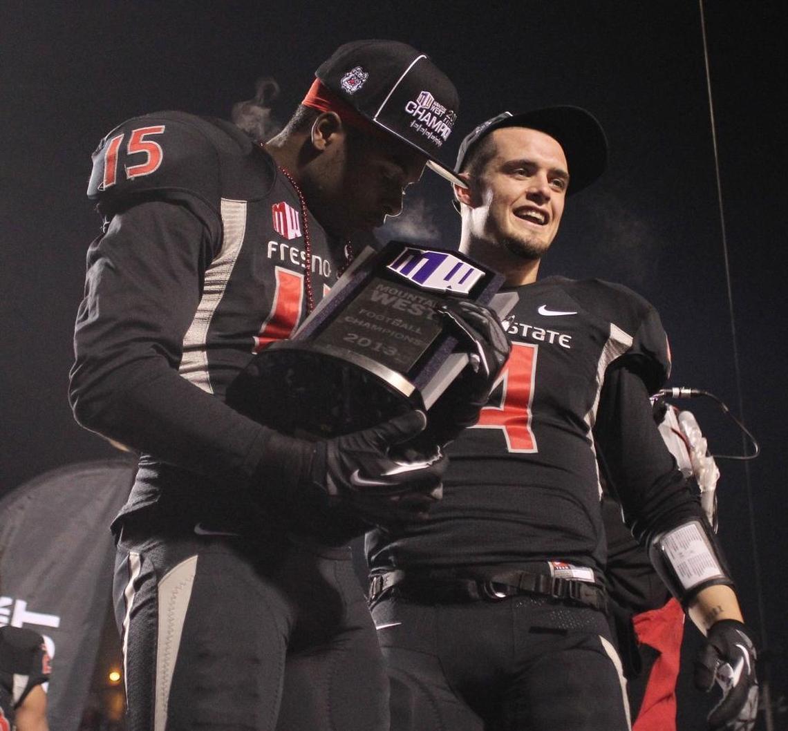 Davante Adams, left, kisses the Mountain West Conference championship trophy while standing beside Derek Carr following the Bulldogs’ victory over Utah State in December 2013 at Bulldog Stadium.