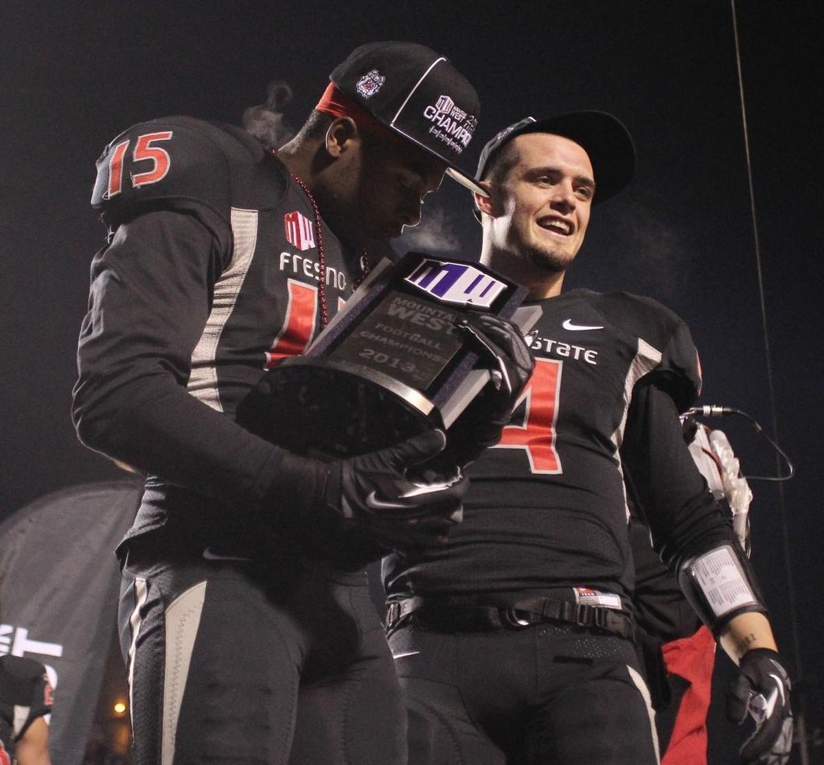 Davante Adams, left, kisses the Mountain West Conference championship trophy while standing beside Derek Carr following the Bulldogs’ victory over Utah State in December 2013 at Bulldog Stadium.