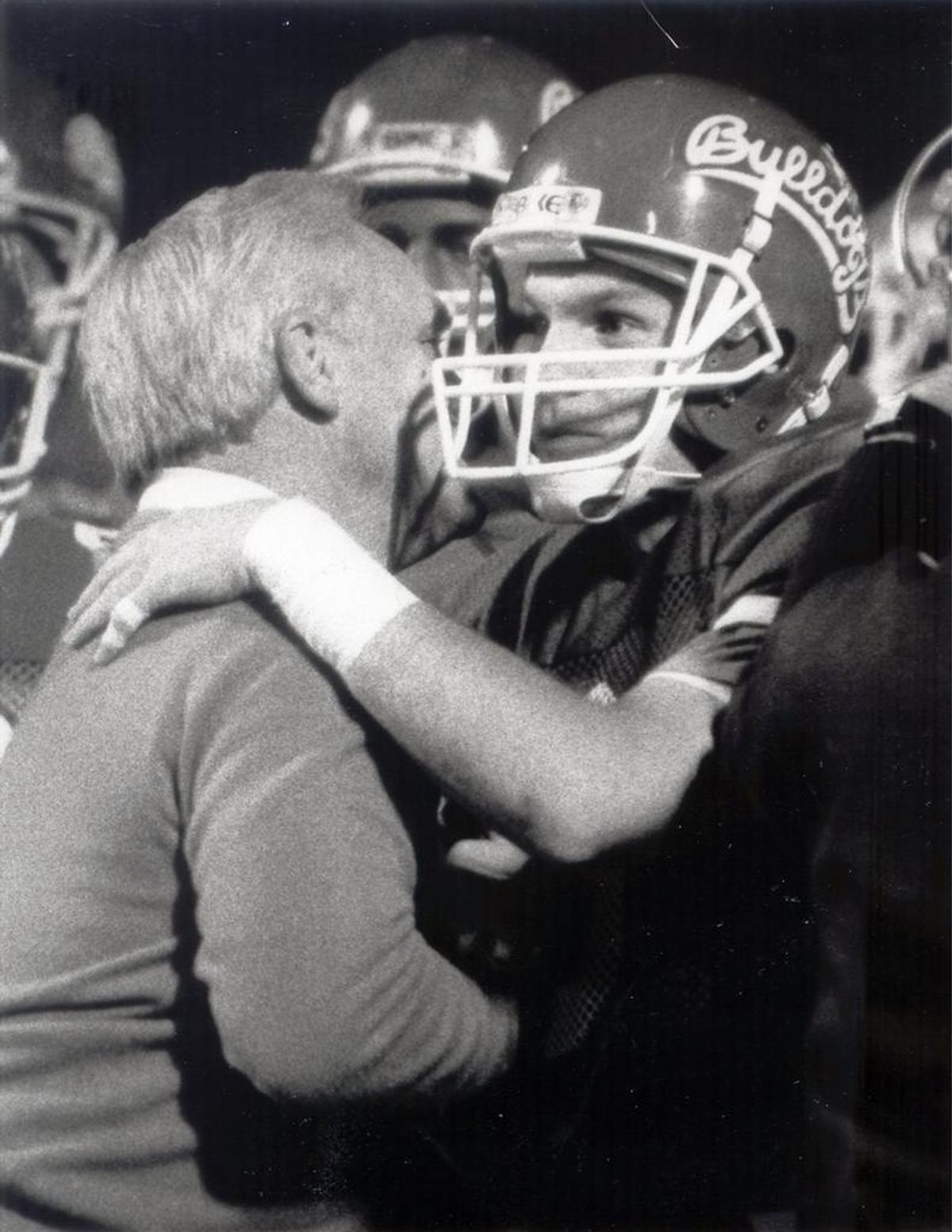 Fresno State quarterback Kevin Sweeney celebrates with his father and head coach Jim Sweeney after a game in 1986.