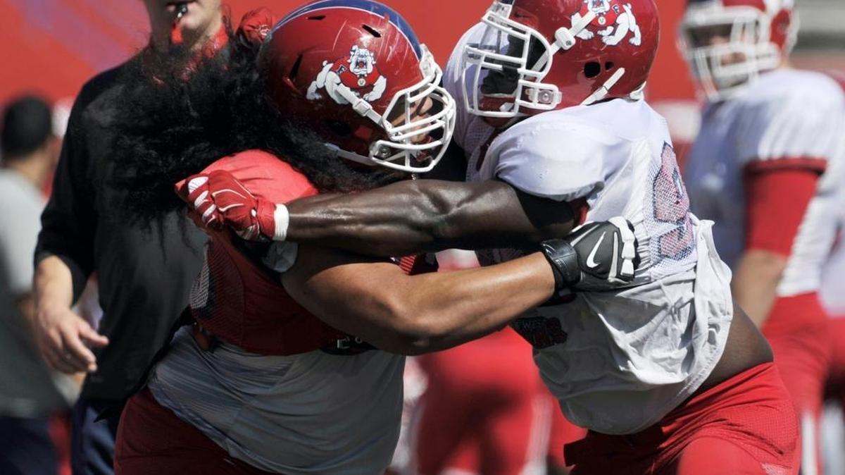 
Offensive lineman Alex Fifita, left, wrangles with defensive end Claudell Louis in the Bulldog Drill at Fresno State’s annual Spring Showcase. Fifita entered his senior season having played 35 games with 25 starts through his first three years in the program.
