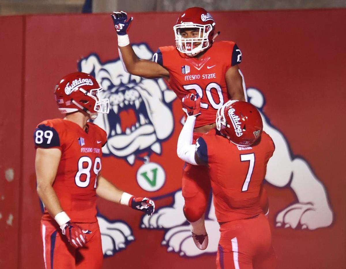 Fresno State’s Derrion Grim, right, lifts Ronnie Rivers after scoring a touchdown in the Bulldogs’ 50-20 victory over Hawai’i, with Kyle Riddering to the left Saturday, Oct. 27, 208 in Fresno. Rivers rushed for 125 yards on 11 plays including a 76-yard touchdown run in the second quarter.