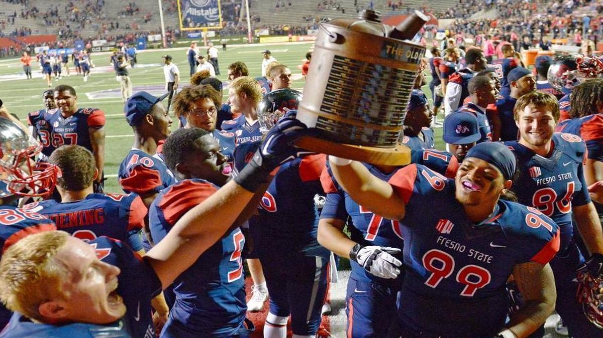 Fresno State players hold up the Old Oil Can Trophy after beating San Diego State at Bulldog Stadium in 2014. The trophy goes to the winner of the annual matchup.
