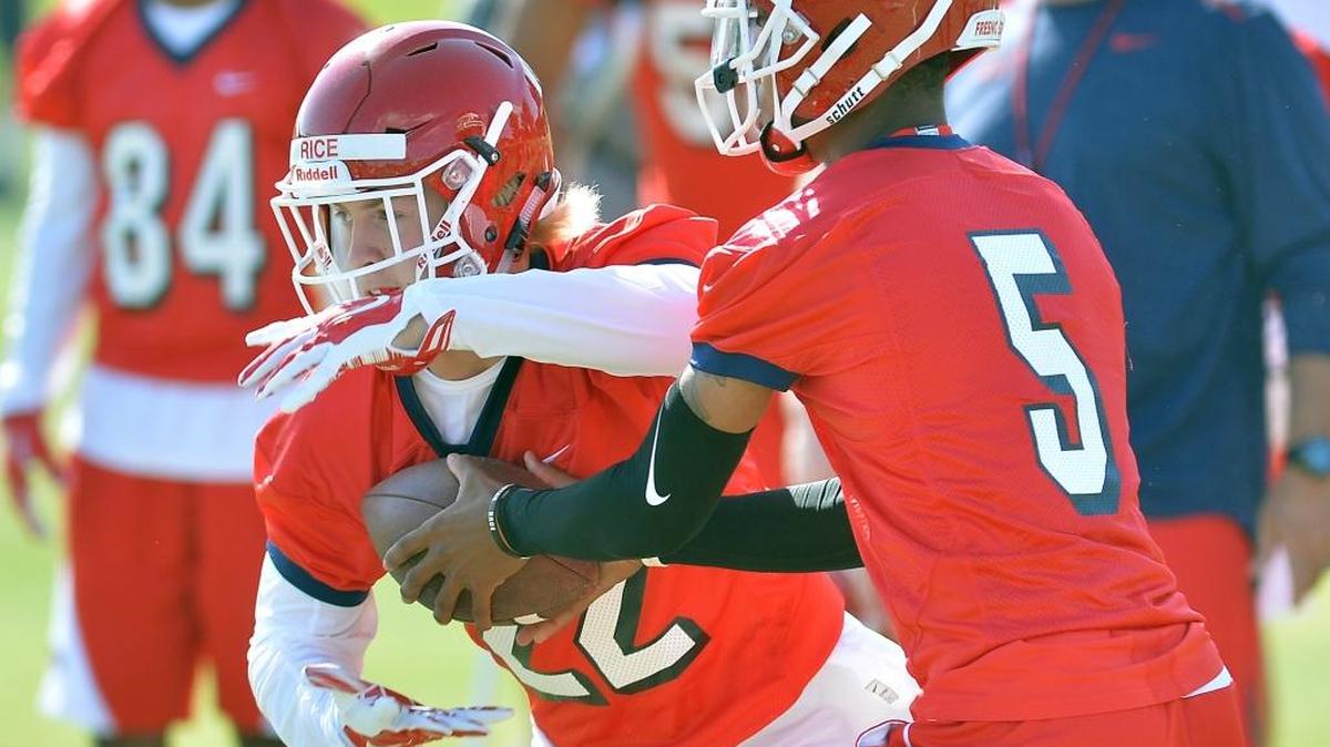 Fresno State running back Justin Rice, left, takes a handoff from quarterback Chason Virgil on the first day of fall camp on Aug. 4. Rice, a freshman from Central Catholic High-Modesto, could see a bump in playing time on Saturday at Colorado State.