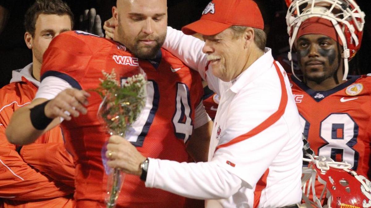Former Fresno State center Joe Bernardi gets a hug and a bouquet from Coach Pat Hill on before his final home game during the 2010 season. Bernardi returns to the Bulldogs as tight ends coach.