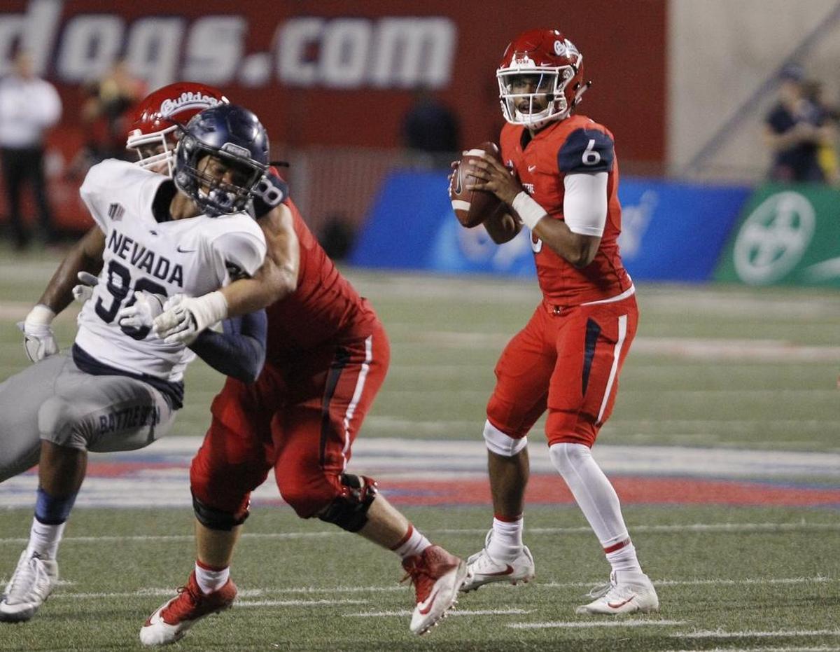 Fresno State quarterback Marcus McMaryion drops back against a Nevada defender in the second half of the game at Bulldog Stadium, Saturday, Sept. 30, 2017. At home this season McMaryion has completed 67.0 percent of his passes, is averaging 9.4 yards per attempt and has seven touchdown passes and just one interception.