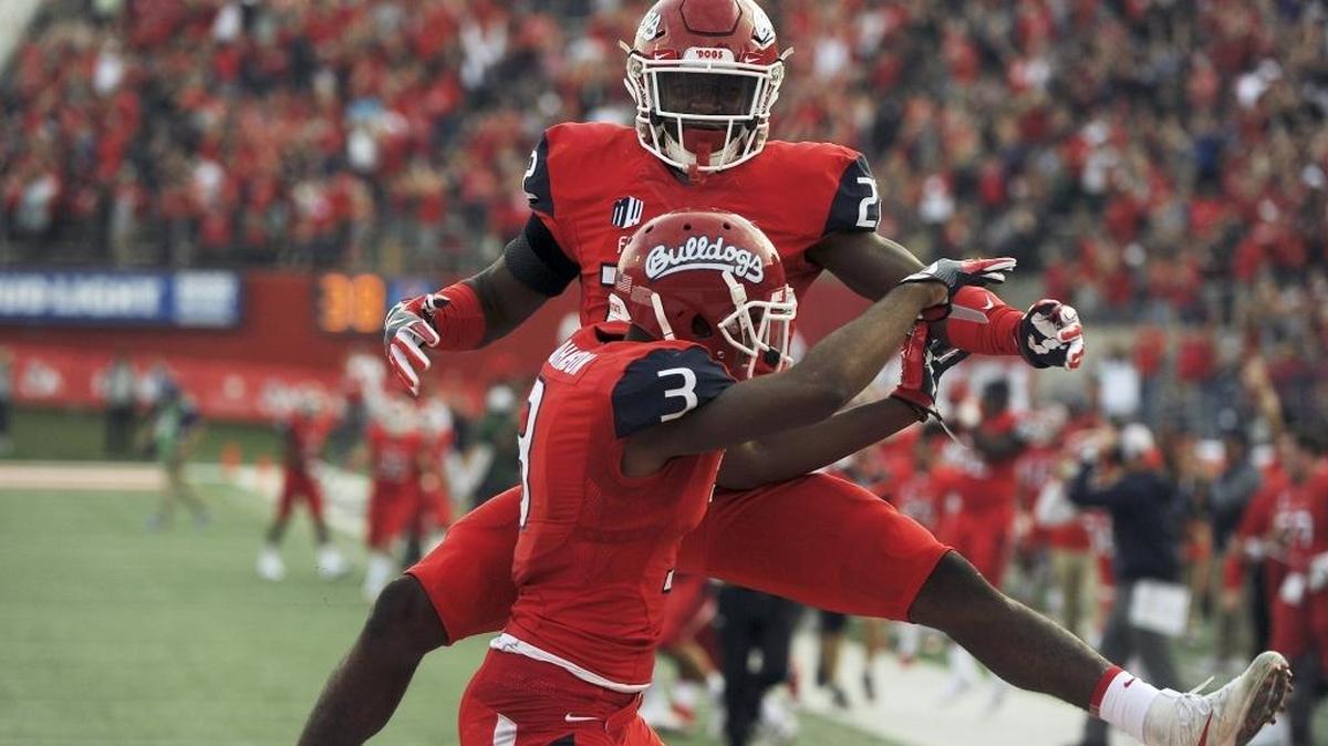 Fresno State’s Jordan Mills, background, celebrates with KeeSean Johnson after Johnson’s touchdown helped seal the Bulldogs’ 28-17 victory over Boise State.