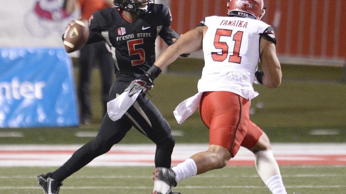 
Fresno State quarterback Chason Virgil, left, looks for an open receiver while being chased by Utah’s Jason Fanaika at Bulldog Stadium, on Sept. 19, 2015. Virgil, a true freshman making his first career start against, suffered a broken clavicle against the Utes and is out for the season.

