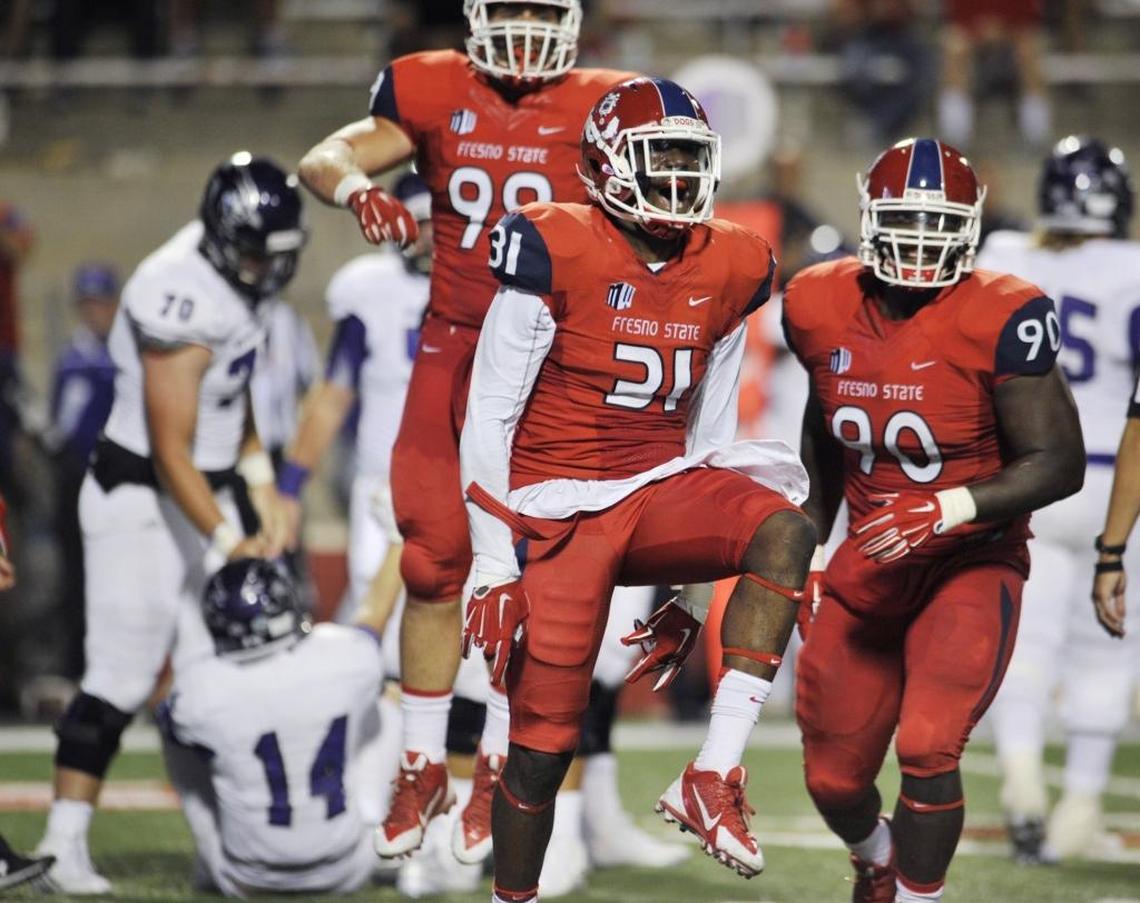 Fresno State linebacker Ejiro Ederaine, center, celebrates a September 2015 sack.