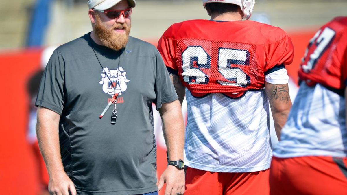 
Fresno State football offensive line coach Cameron Norcross keeps an eye on linemen during practice Aug. 7, 2014.
