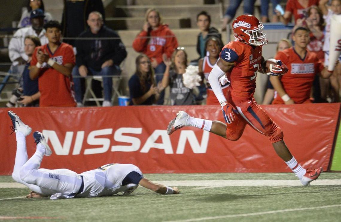 Fresno State defensive end Mykal Walker, right, evades a defender before dashing into the end zone for an interception return for a touchdown in the Bulldogs’ 49-27 victory over the Toledo Rockets at Bulldog Stadium on Saturday, Sept. 29, 2018.