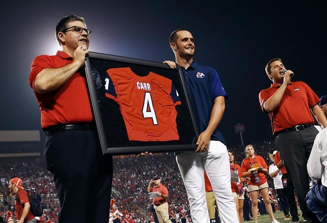 Fresno State president Dr. Joseph Castro, left, poses with Derek Carr and Carr’s retired No. 4 jersey during halftime in the Bulldogs’ season-opening victory over Incarnate Word on Saturday, Sept. 2, 2017 at Bulldog Stadium