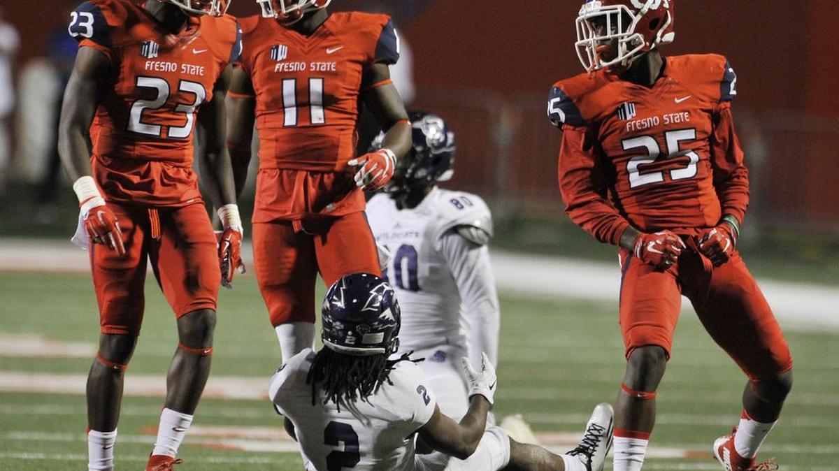 
Fresno State’s Alan Wright, left, DeShawn Potts, center, and Tyquwan Glass, right, stand over Abilene Christian wide receiver Jonathan Epps late in the second half Thursday.
