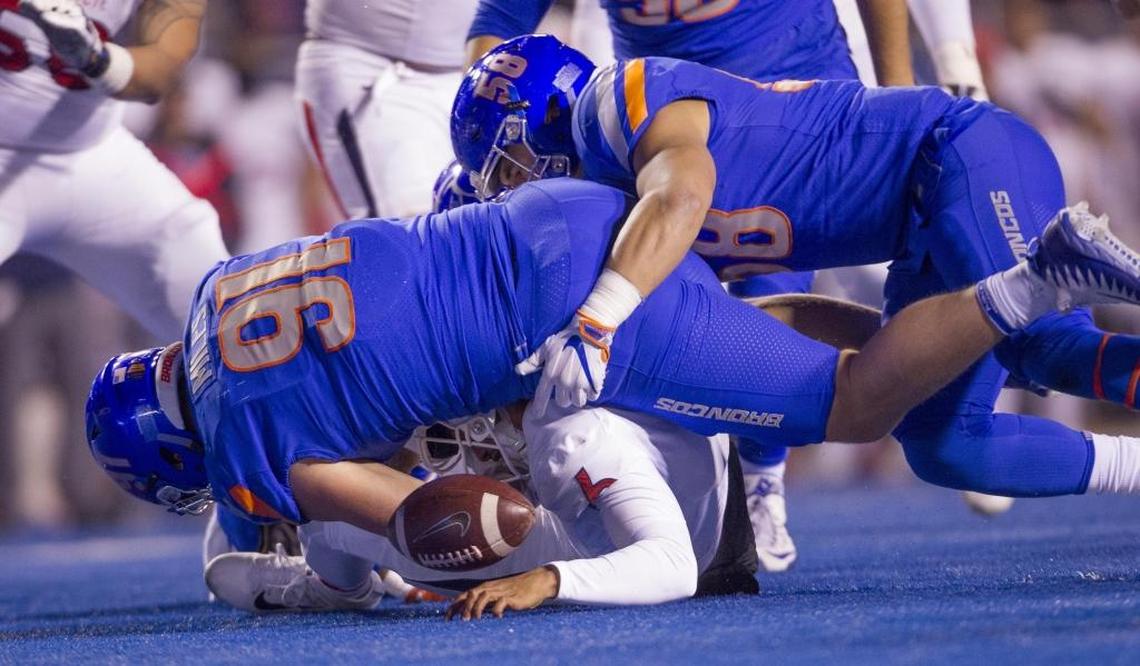 Boise State defensive end Durrant Miles (91) and linebacker Tyson Maeva (58) force a loose ball while collapsing on Fresno State quarterback Marcus McMaryion. Fresno State recovered.