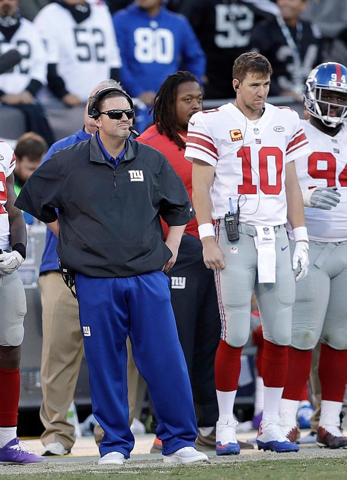 New York Giants coach Ben McAdoo stands next to quarterback Eli Manning (10) during Sunday’s 24-17 loss to the Oakland Raiders. Manning was benched the week of the game, ending a streak of 210 consecutive starts. McAdoo was fired the next day.