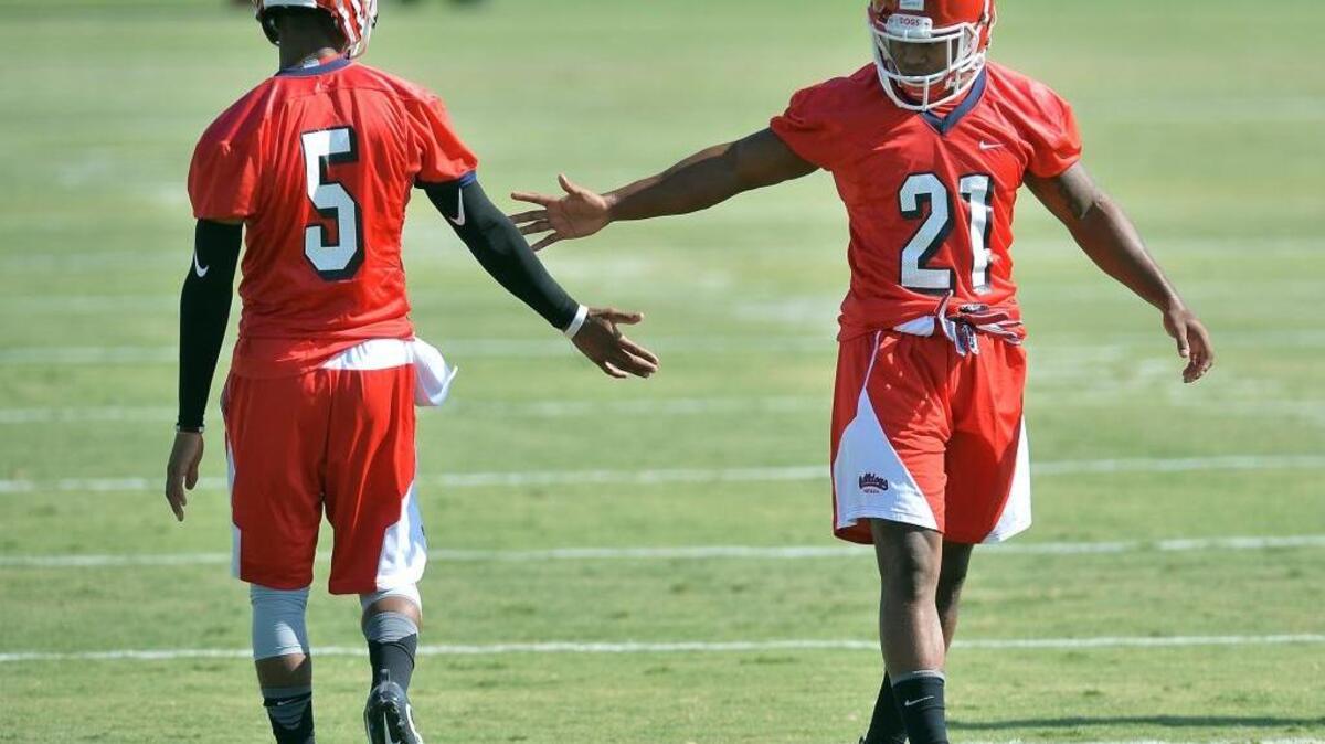 Quarterback Chason Virgil, left, and running back Dontel James exchange greetings on the first day of Fresno State’s fall camp Aug. 4, 2016. James, who had knee surgery Aug. 12, is moving closer to full participation at Bulldogs practices after going through through individual drills, 7 on 7, team periods and even one rep during a live run Tuesday.