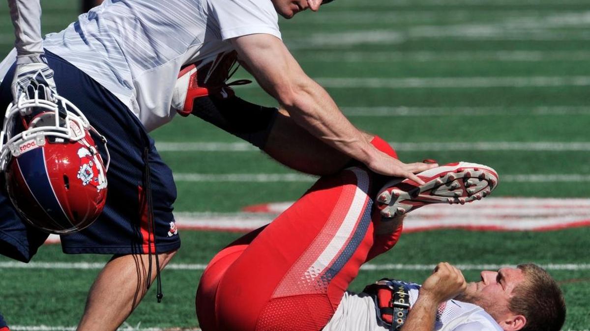 Head strength coach Joey Boese helps inside linebacker Jeff Camilli stretch during Fresno State’s annual Spring Showcase on March 28, 2015. The Bulldogs will revamp their workout regimen in 2016 to spread spring practices across five weeks rather than four while also adding an extra weight-training day per week.