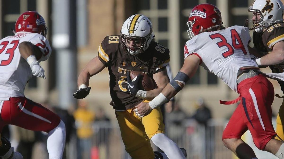 Fresno State defenders Juju Hughes, left, and George Helmuth converge on Wyoming tight end Austin Fort.