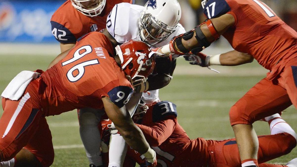 Fresno State defenders put up a wall to stop Nevada running back James Butler at Bulldog Stadium on Nov. 5, 2015.