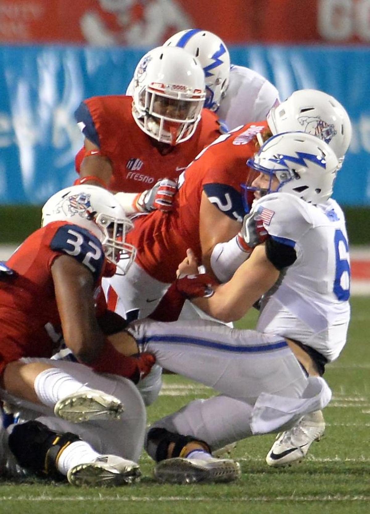 Fresno State linebacker Trent Soechting (22) and defensive end Robert Stanley (32) sack Air Force quarterback Nate Romine in a 2016 game. Soechting will be playing against his hometown team, Houston, in the Hawaii Bowl.