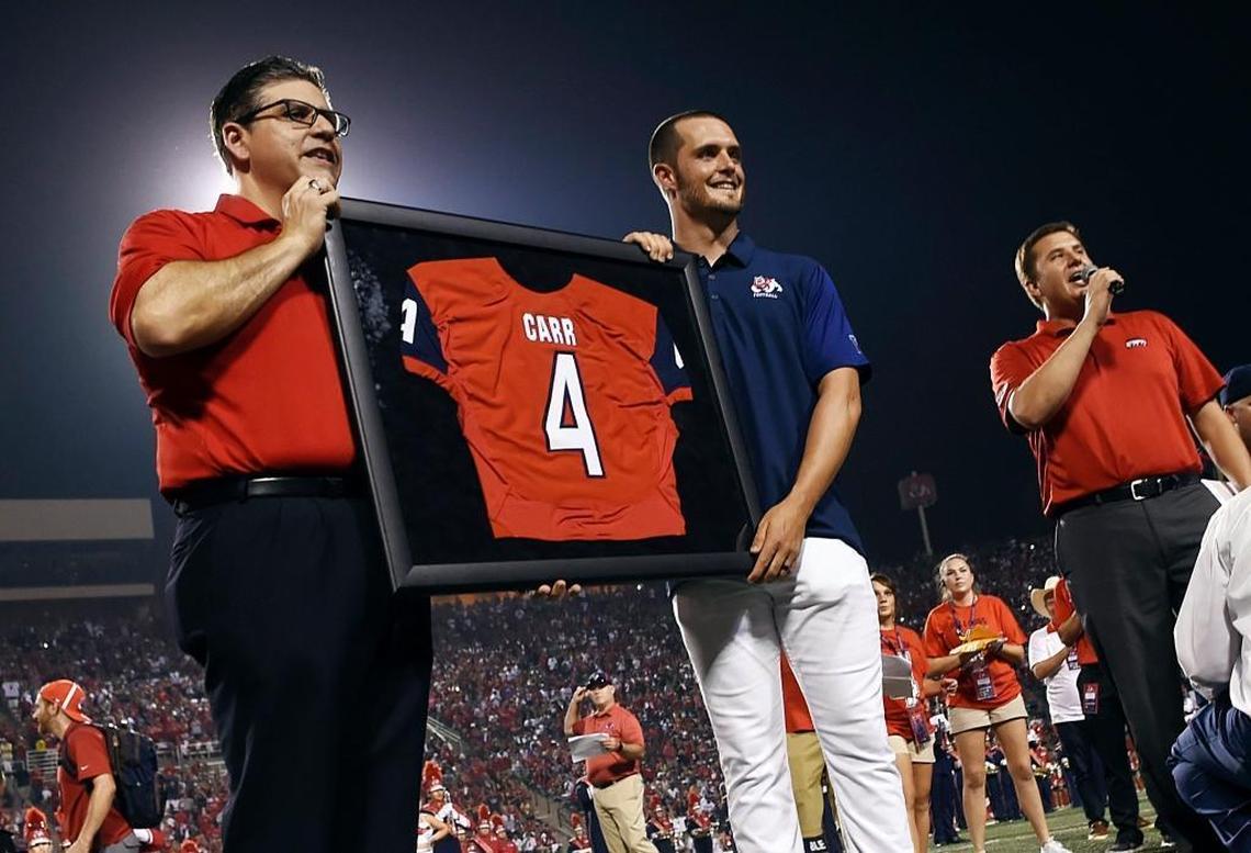 Fresno State president Dr. Joseph Castro, left, poses with Derek Carr and Carr’s retired No. 4 jersey during halftime in the Bulldogs’ season-opening victory over Incarnate Word on Saturday, Sept. 2, 2017 at Bulldog Stadium