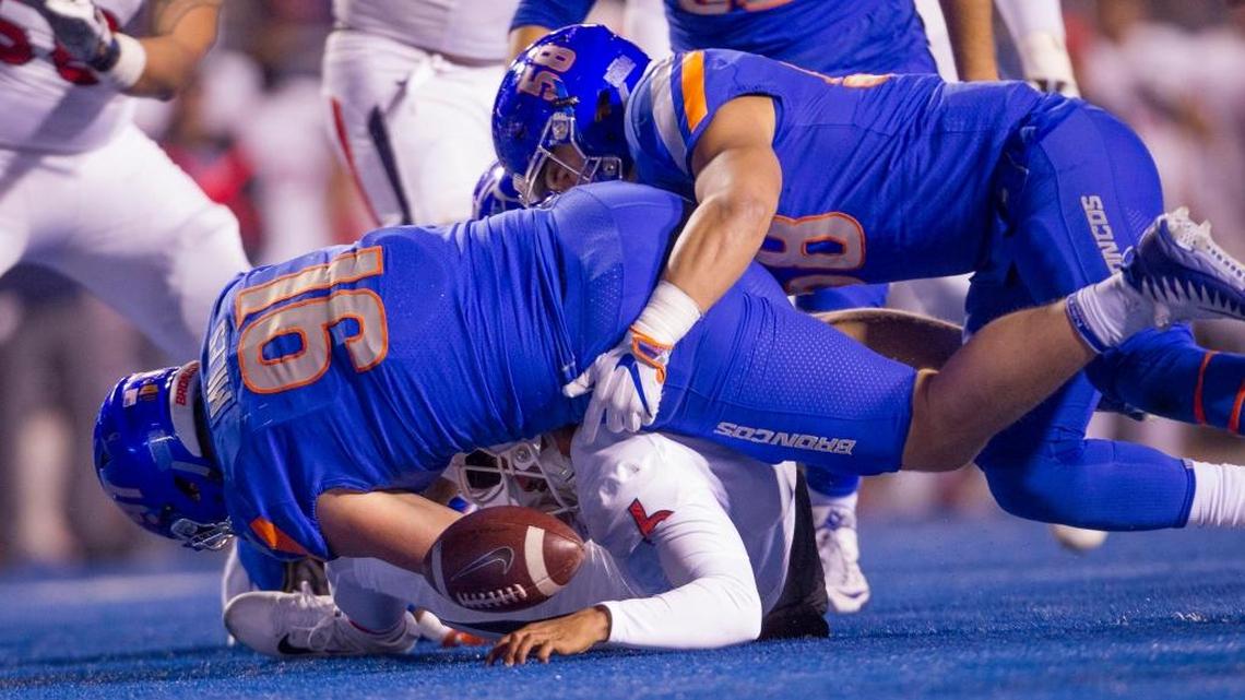 Boise State defensive end Durrant Miles (91) and linebacker Tyson Maeva (58) force a fumble when sacking Fresno State quarterback Marcus McMaryion (6). McMaryion recovered the fumble, but Boise State pulled out a 17-14 victory with a fourth quarter touchdown in the Mountain West Conference Championship Saturday, Dec. 2, 2017 at Albertsons Stadium in Boise.