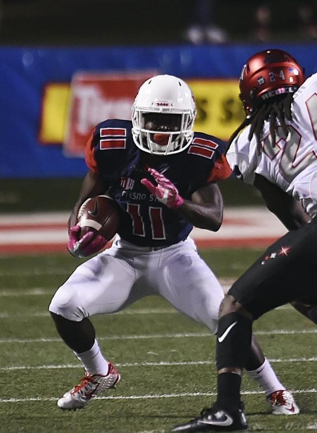 Fresno State running back Dejonte O’Neal, left, makes a cut outside to avoid UNLV’s Robert Jackson on Saturday, Oct. 28, 2017, at Bulldog Stadium.