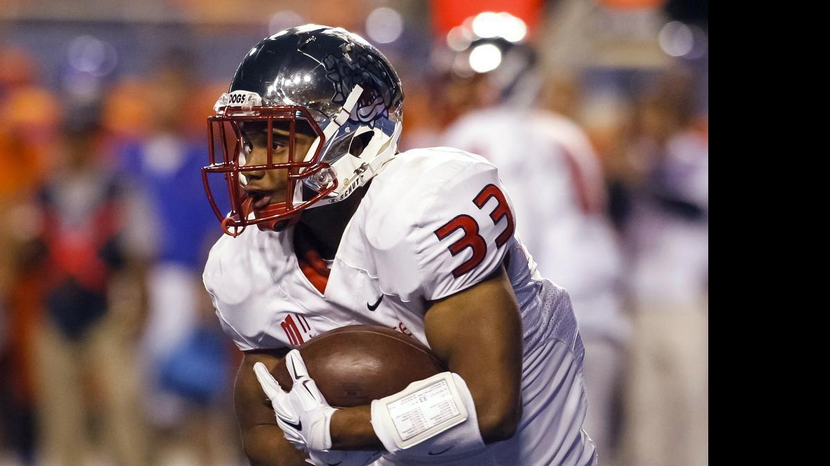 
Fresno State running back Marteze Waller cradles the ball during the first half of last season’s game at Boise State.
