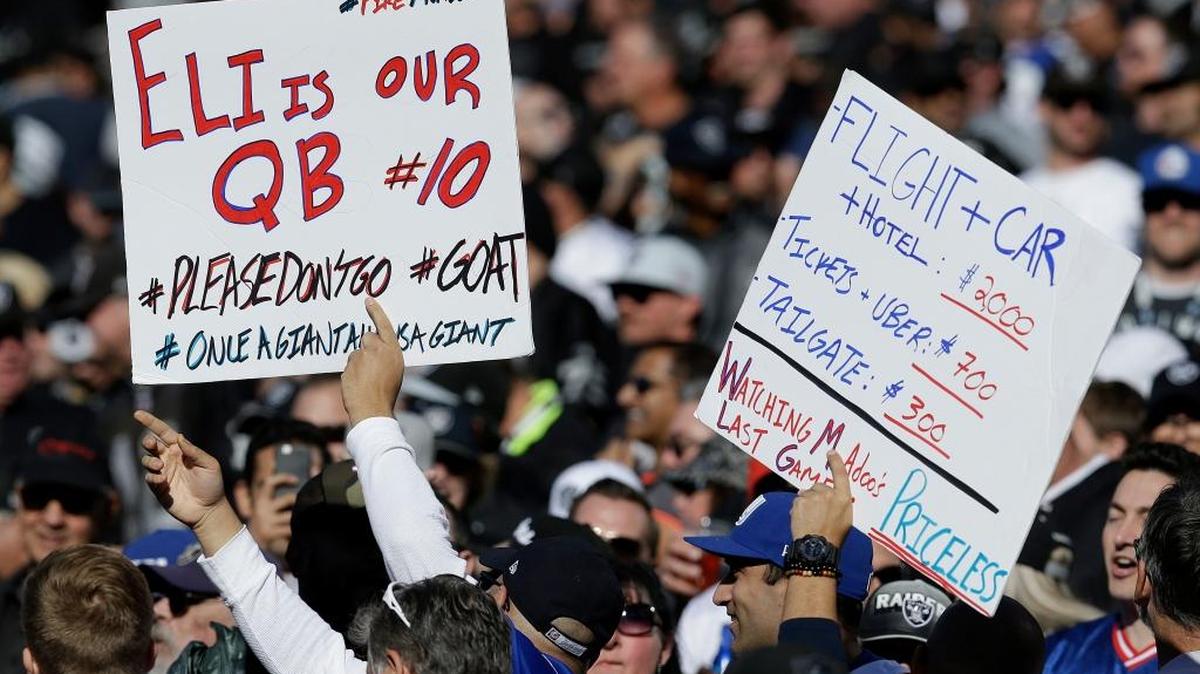 Fans hold up signs in support of New York Giants quarterback Eli Manning during Sunday’s 24-17 loss at Oakland. Manning was benched last week by former coach Ben McAdoo, ending a run of 210 consecutive starts.