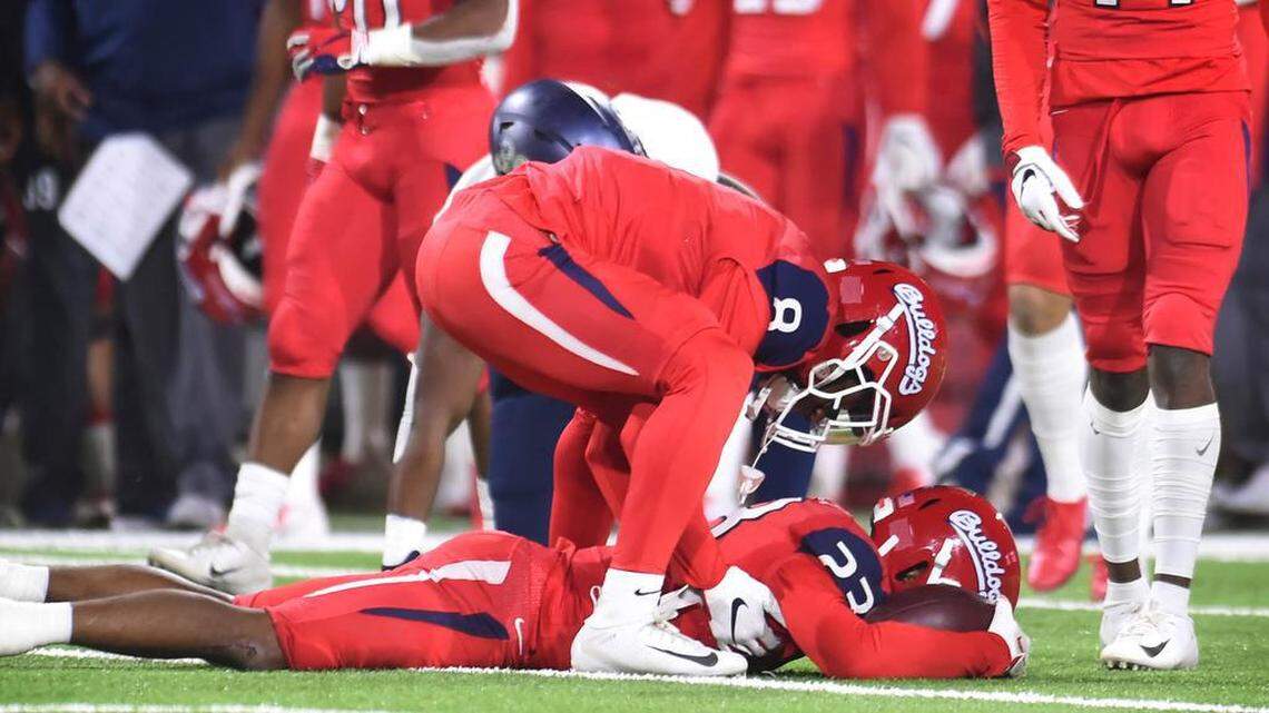 Fresno State’s Chris Coleman, center, stands over JuJu Hughes after Hughes was tackled on the last play of the game Saturday, Nov. 23, 2019 in Fresno. Nevada ended a 28-28 tie to win 35-28.