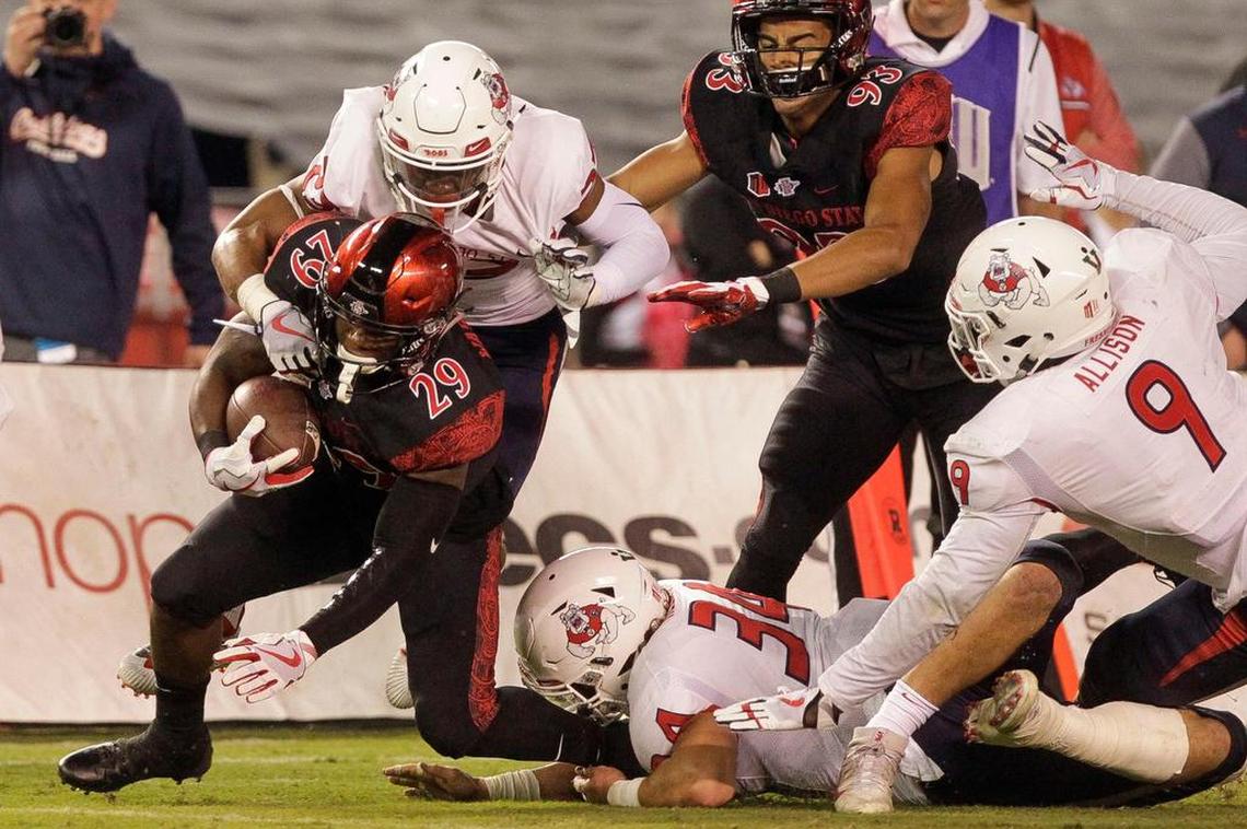 Fresno State safety Juju Hughes, top left, tackles San Diego State running back Juwan Washington (29) during the first quarter of the Bulldogs’ victory over the Aztecs at SDCCU Stadium in San Diego on Saturday, Oct. 21, 2017..