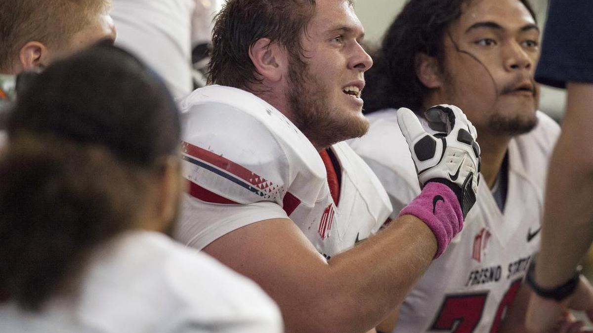 
Fresno State’s Bo Bonnheim, at center talking to a coach during the Bulldogs’ 2013 game at Idaho, is a former walk-on player who said the added cost of attendance stipend to his 2015 scholarship checks is a “credit to everyone that got that set up for us, that went to the lengths to get us that extra money.” The senior center added jokingly that he’d now be opening a savings account.
