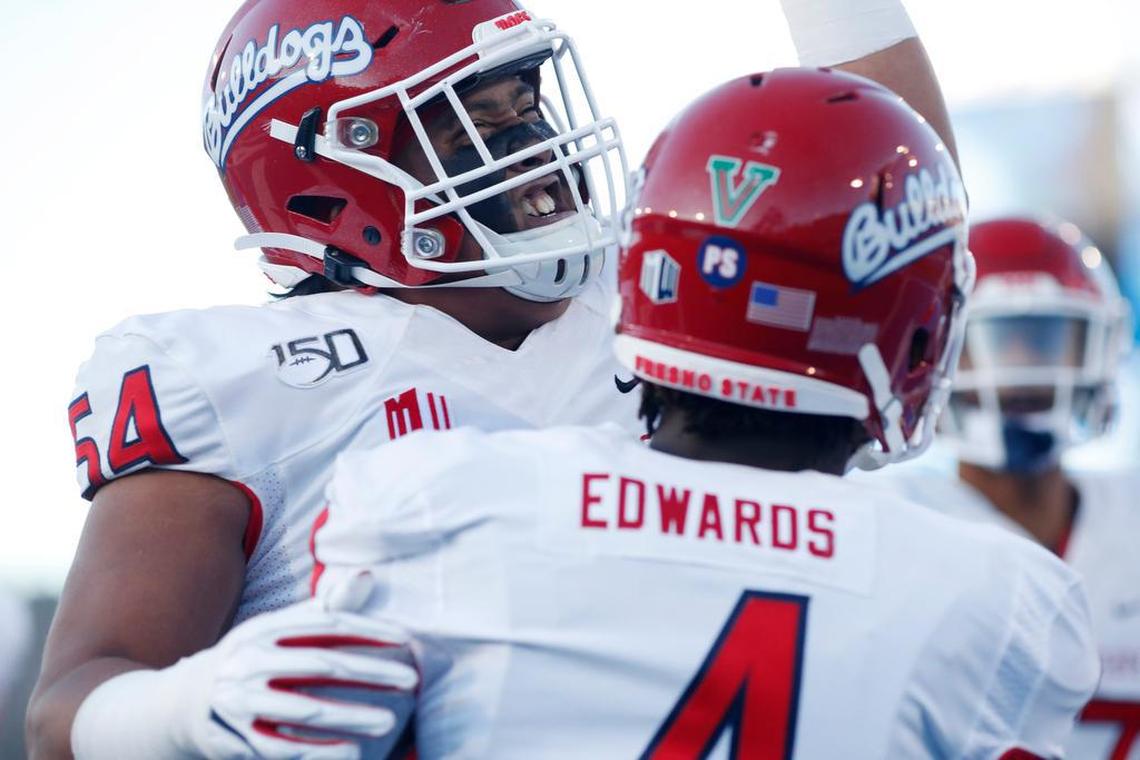Fresno State offensive lineman Bula Schmidt, back, congratulates wide receiver Emoryie Edwards after his touchdown reception against Air Force in the first half of Saturday’s game.