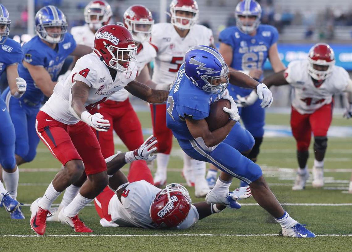 Air Force fullback Timothy Jackson is stopped after a short gain by Fresno State defensive back Wylan Free, left, and linebacker Mykal Walker in the first half of Saturday’s game.