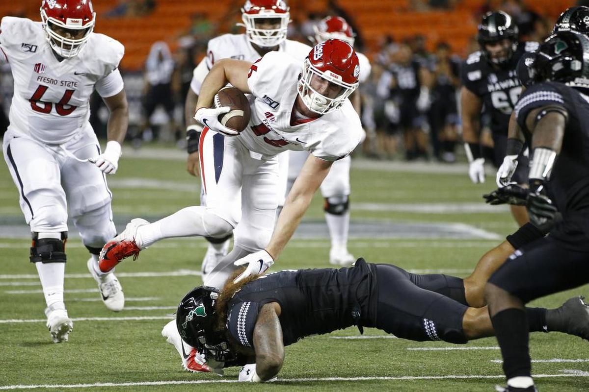 Fresno State tight end Jared Rice (16) steps over Hawaii linebacker Jeremiah Pritchard (2) in the Bulldogs’ 41-38 victory over the Rainbow Warriors Saturday, Nov. 2, 2019, in Honolulu. Rice caught four passes for 46 yards and one touchdown.
