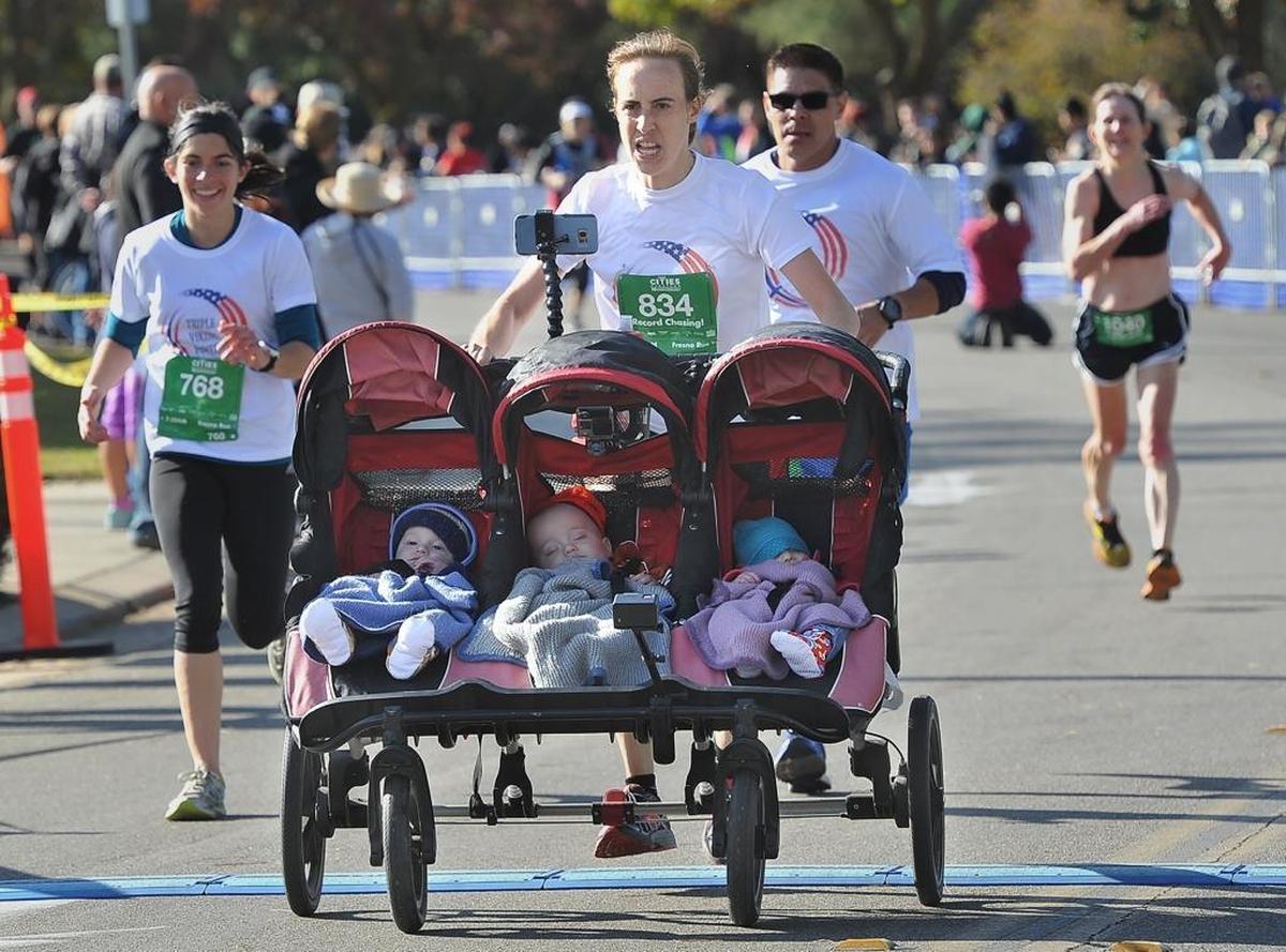 Ann Marie Cody of Sunnyvale turns on the afterburners as she nears the finish line pushing her triplets-snug in their triple stroller- in the Fresno Half Marathon race, Sunday morning, Nov. 5, 2017, to set a Guiness World Record, for the fastest half marathon pushing a triple stroller, for a finish time of one hour, 48 minutes. She wouldn’t give the kids’ names, calling them her “Triple Viking Clan.”